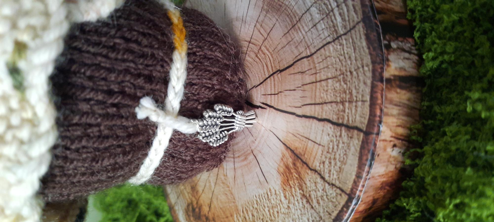 Close-up of Mabon's wheat charm and knitted details